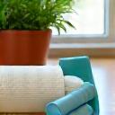 Mancuernas de bajo impacto y banda de resistencia en una esterilla de yoga en casa.